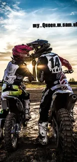 Two motocross riders sharing a moment under a stunning sunset.