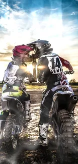 Motocross riders pause at sunset on a scenic dirt track.