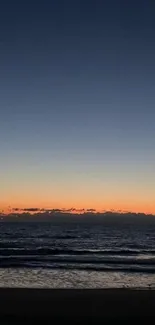 Serene ocean view at sunset with calm waters and a colorful sky.