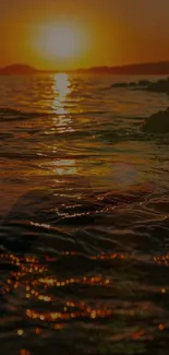 Golden sunset over ocean waves with reflective water.