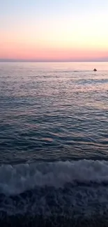 Serene sunset over ocean with waves and a colorful gradient sky.