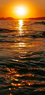 Sunset over ocean with shimmering water.