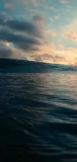 Peaceful sunset over ocean waves with a cloudy sky.