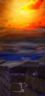 Dramatic sunset over an ancient stone wall with vibrant orange clouds.