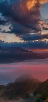 Stunning sunset over misty mountains with vibrant clouds.