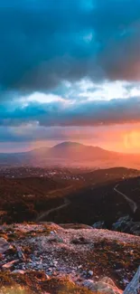 Scenic sunset over a mountain landscape with vibrant orange hues.