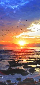 Vibrant sunset over ocean with flying birds and colorful sky.