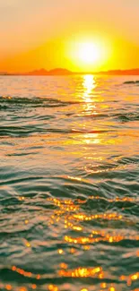 Golden sunset over ocean with shimmering waves.