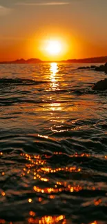 Sunset over ocean waves with vibrant orange hues.