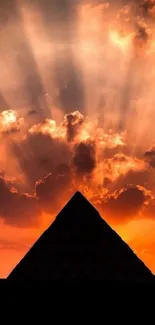 Pyramid silhouette with sunset rays casting dramatic sky shadows.