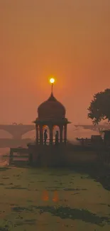 Scenic sunset over a riverside pavilion with warm hues.