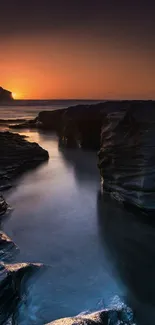 Mesmerizing sunset over rocky shores with a serene ocean view.