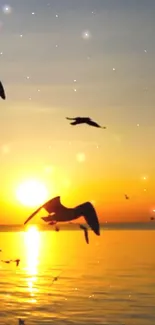 Birds silhouetted against a serene sunset over the sea.