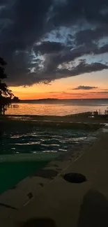 Mobile wallpaper of a sunset over a tranquil lake with dark clouds and vibrant colors.