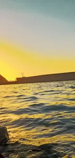 Vibrant sunset reflecting over tranquil water with a silhouette of a cliff.