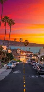 Colorful sunset street scene with palm trees and ocean.