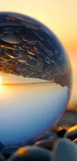 Crystal ball reflecting a serene sunset on a tranquil beach.