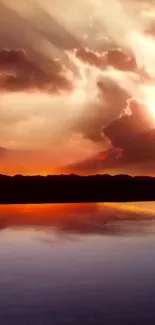 Sunset reflecting on calm water with vibrant orange and cloudy sky.