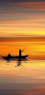 Silhouette of two boaters on calm water against a vibrant sunset.