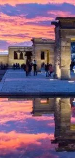 Sunset reflection at ancient temple with vibrant sky and serene water.