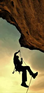 Silhouette of a rock climber at sunset against a dramatic sky.