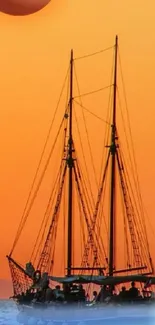 Sailboat silhouetted against an orange sunset on the ocean water scene.