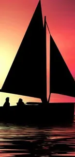 Silhouetted sailboat at sunset on calm waters.