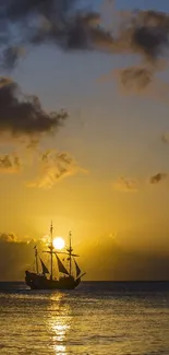 Sailboat silhouette at sunset on the sea with a golden sky.