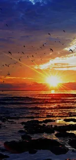 Vibrant sunset over ocean with birds soaring in the colorful sky, creating a serene view.