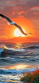 Seagulls flying over an ocean with a vibrant sunset.