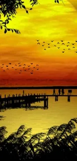 Vibrant sunset wallpaper with birds over lake.