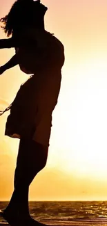 Silhouette of a woman at sunset on the beach, embracing the serene ocean view.