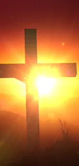 Silhouette of a cross against a vivid orange sunset sky.