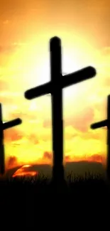 Three crosses silhouetted against a glowing sunset sky.