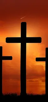 Silhouetted crosses at sunset with dramatic sky.