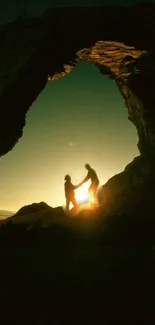 Silhouette of two people at sunset in a rock arch, with glowing golden sky.