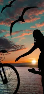 Girl and bicycle silhouette at sunset, birds flying.