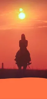 Silhouette of person on horse at sunset with orange sky.