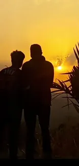 Silhouette of friends at sunset with golden sky.