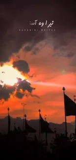 Silhouetted flags against a crimson sunset sky with dramatic clouds.