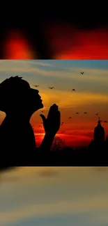 Silhouette of a praying figure against a vibrant sunset sky.