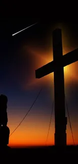 Kneeling silhouette by glowing cross at sunset.