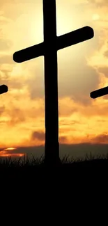 Silhouette of three crosses against a vibrant sunset sky.