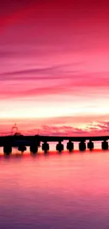 Silhouette on a dock with a vibrant pink sunset.