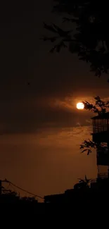 A dark silhouette of buildings against a sunset sky.