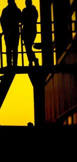 Silhouette of figures on stairs against a bright yellow sunset backdrop.