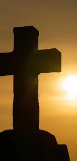 Silhouette of a cross at sunset with a golden sky.