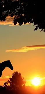 Silhouette of a horse against a vibrant sunset with tree leaves.