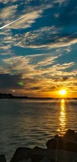 Sunset over the ocean with clouds and a calm horizon.