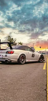 Street racing car at sunset, urban backdrop.